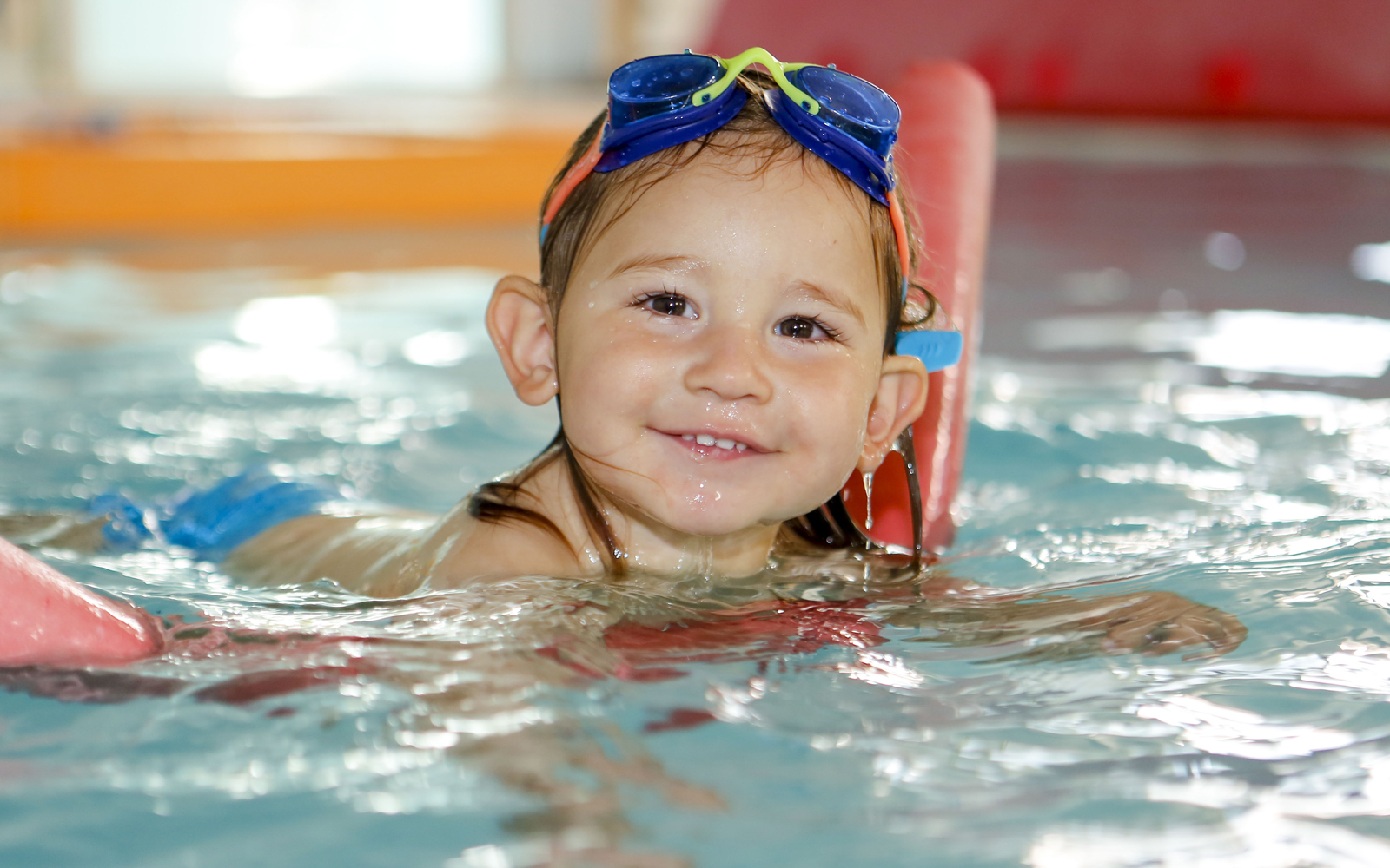 Enfant souriant dans la piscine chauffée d'Eden Kids Montpellier